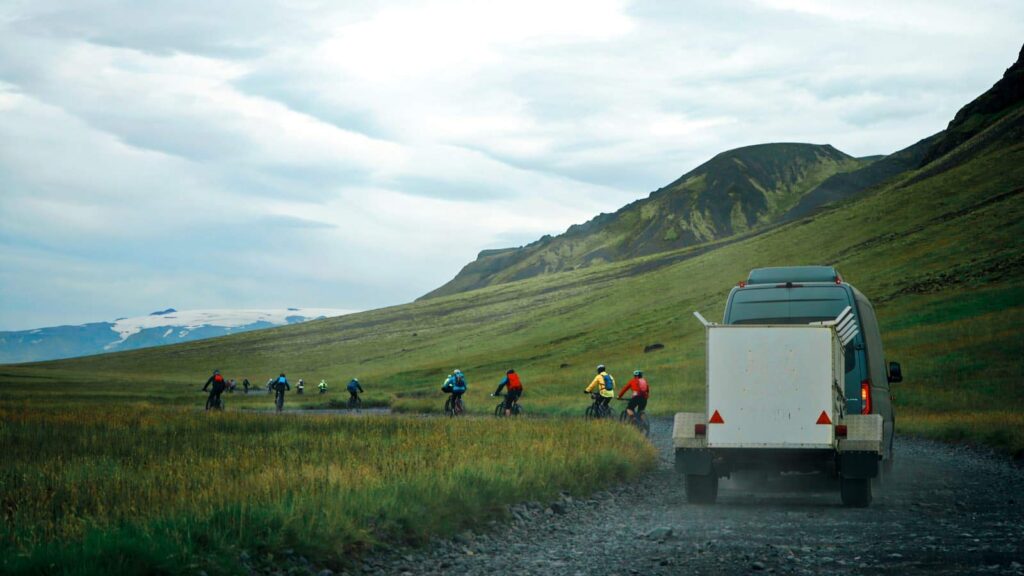 Van with trailer helping cyclist on the way to Þórsmörk